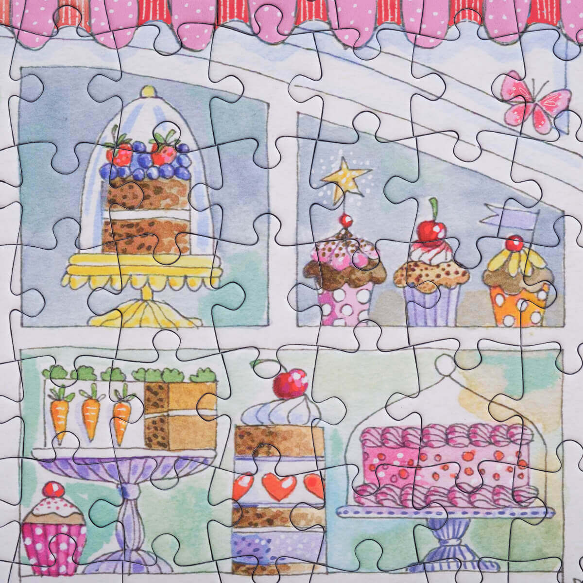 Bloom Puzzles Le Cafe 500 piece Puzzle Close Up of Cakes in the Window