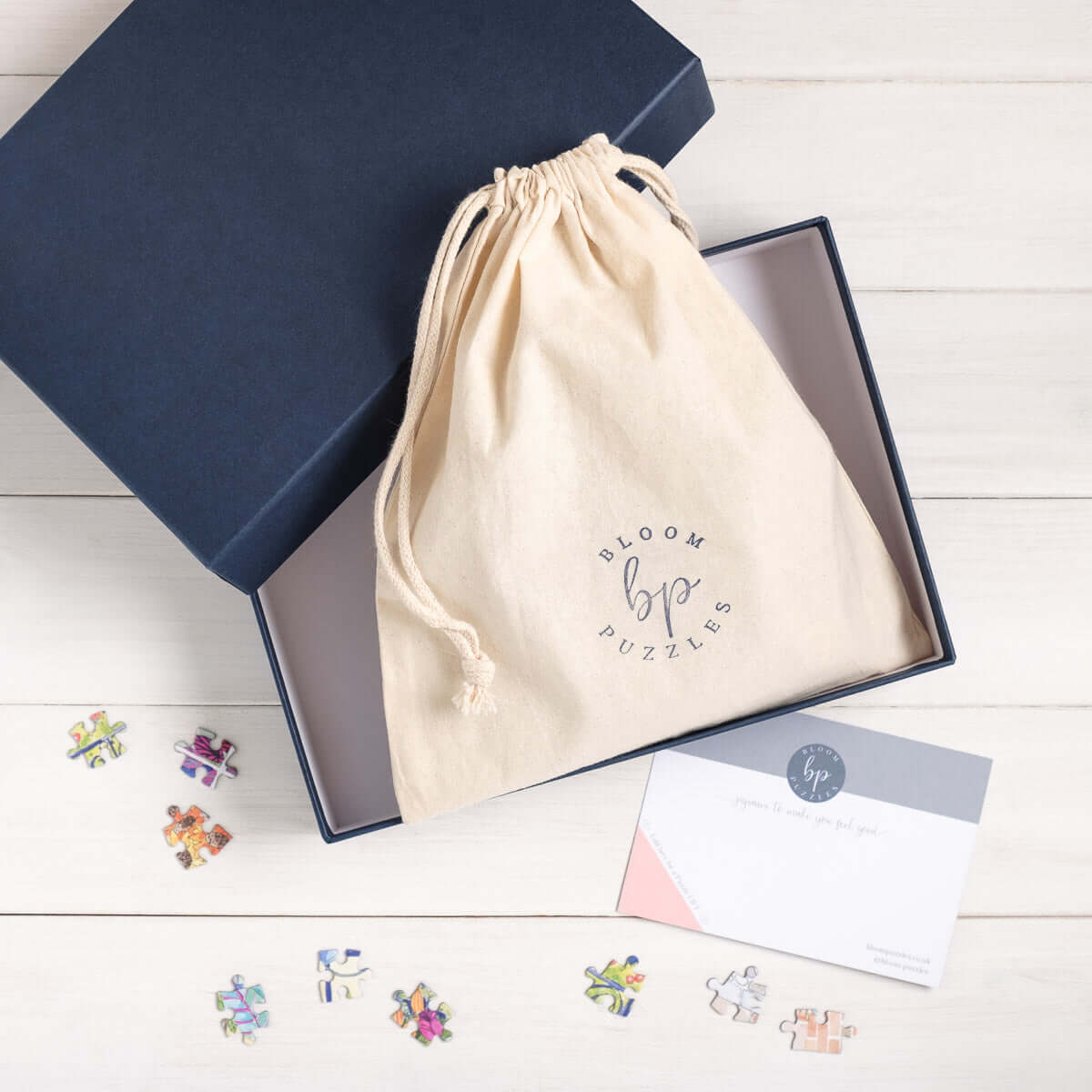 Open Puzzle Box with Organic Cotton Bag and puzzle pieces from Bloom Puzzles on a white background