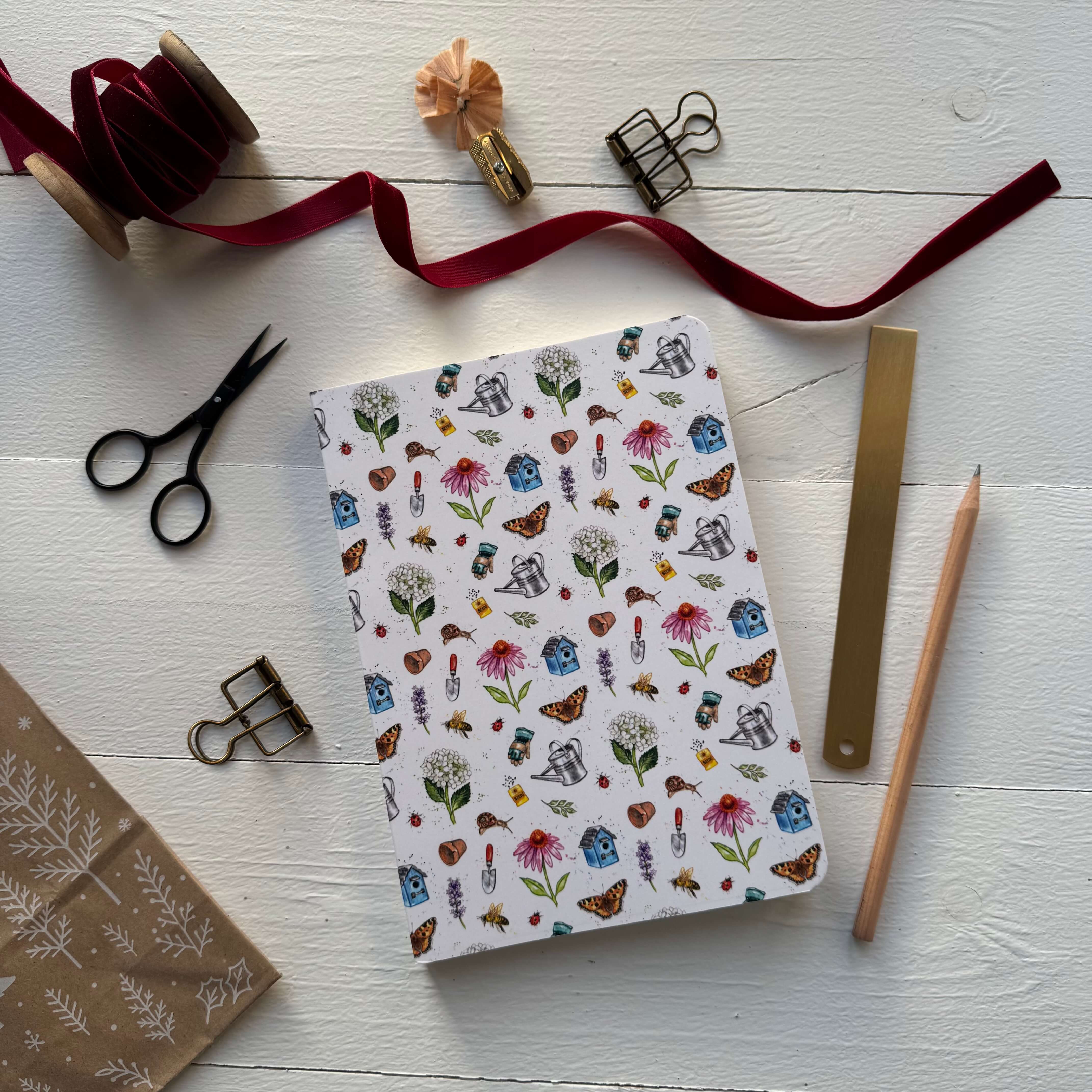 Notebook with garden pattern from The Potting Shed on a white surface with stationery items