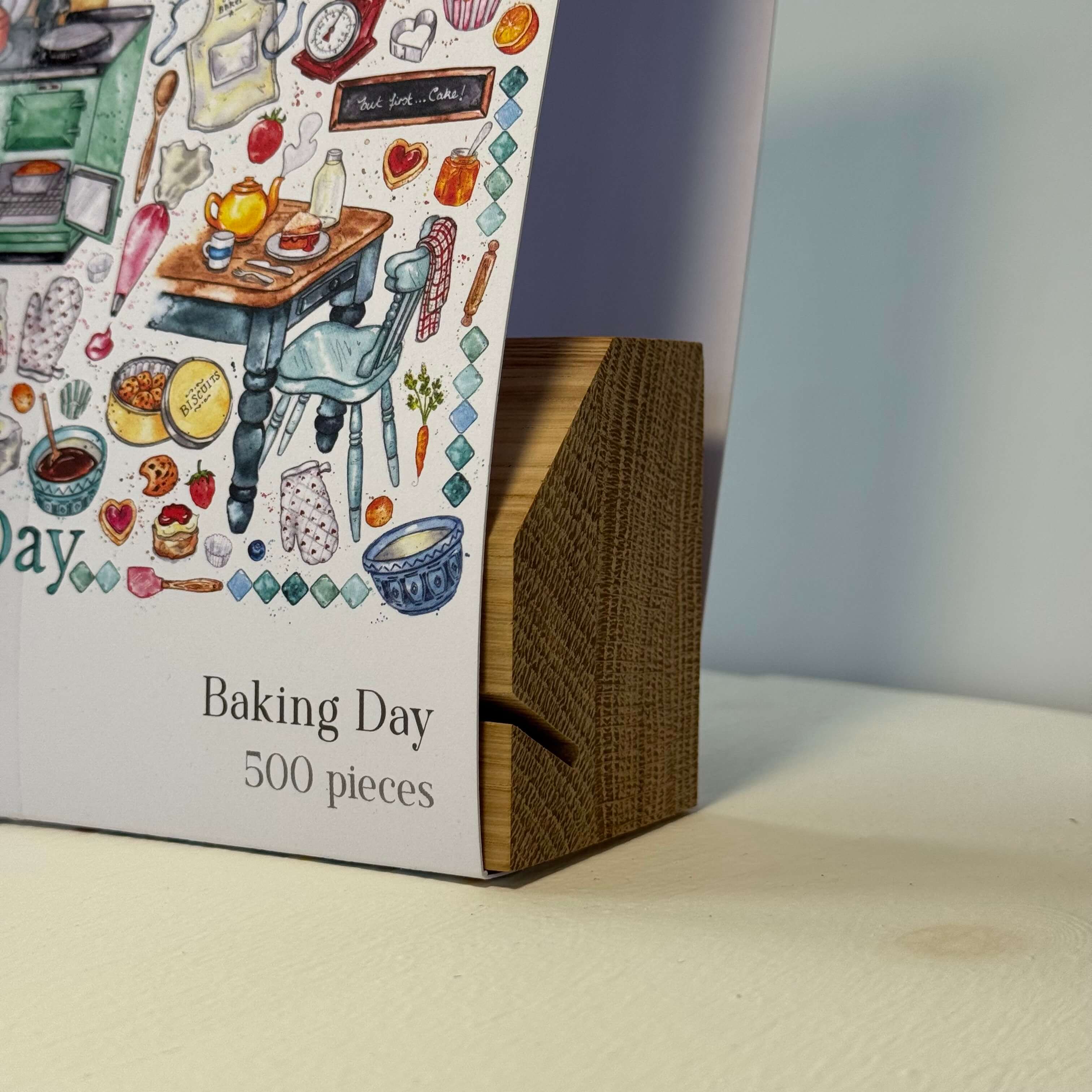 Oak puzzle box stand with 'Baking Day' sleeve on a neutral background